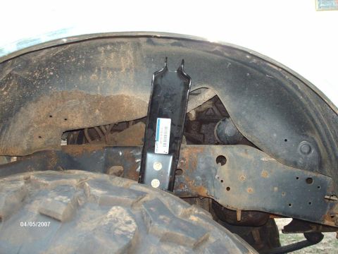 1990 Ford F-150 - Detail shot of a truck's suspension system and wheel well, showing the tire and frame components.