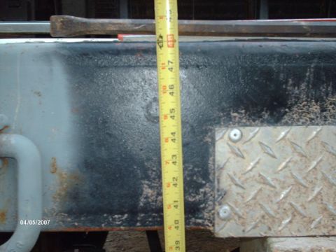1990 Ford F-150 - A measuring tape is placed against the frame of a truck, indicating a height measurement.