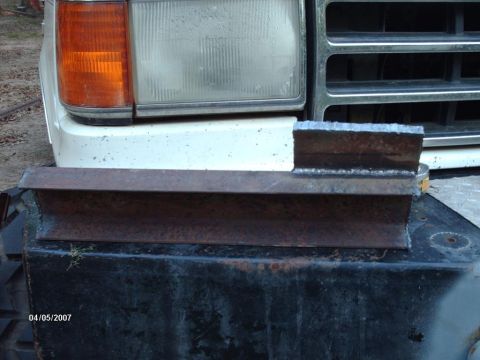 1990 Ford F-150 - A custom welded metal part is attached to the front of a 1990 Ford F-150, likely for a straight axle swap modification.
