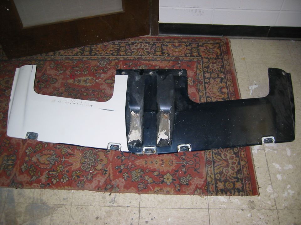 White and black car bumper part with visible text
