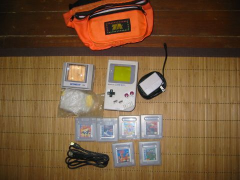 1996 Ford Bronco - Nintendo Game Boy with games, charger, and an orange fanny pack are laid out on a mat.
