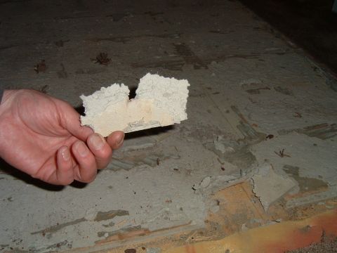 1992 Ford Probe - A hand holds a chunk of insulation material against a damaged concrete surface.