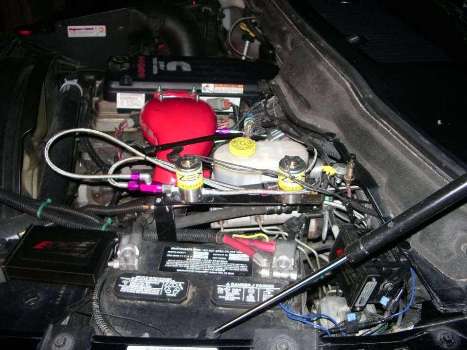 Cummins diesel engine bay with ZEX nitrous solenoids, braided lines, red intake cover, and Edge module