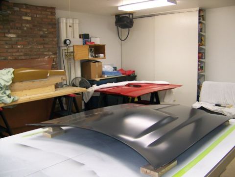 1972 Ford Ranchero - A car hood with prominent vents is displayed in a workshop setting.