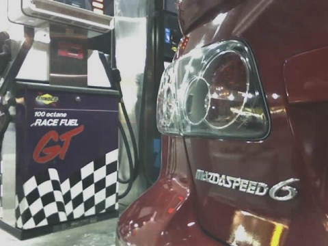 2006 Mazda 6 - Rear view of a red MazdaSpeed 6 at a gas station with a "100 octane RACE FUEL" pump.