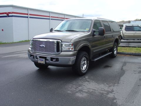 2002 Ford Excursion - A gray 2002 Ford Excursion is parked outside a building with another vehicle in the background.
