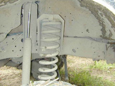 1996 Ford Bronco - The image shows the underside of a vehicle, focusing on the shock absorber and coil spring assembly.