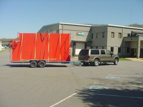 2002 Ford Excursion - A 2002 Ford Excursion is parked outside a building, attached to a large red trailer.