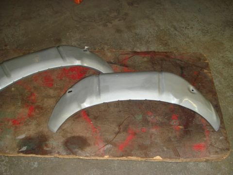 1996 Ford Bronco - Two unpainted metal inner fender sections are shown on a wooden board.
