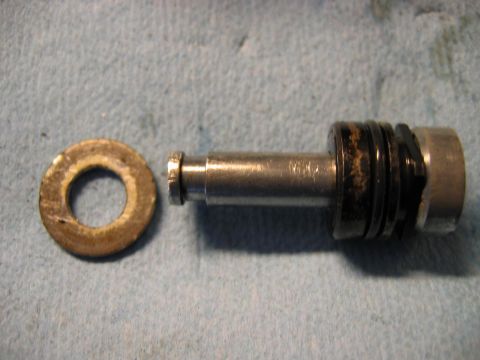 1985 Ford LTD Crown Victoria - Close-up of a disassembled metal part and a washer, likely from a mechanical assembly.