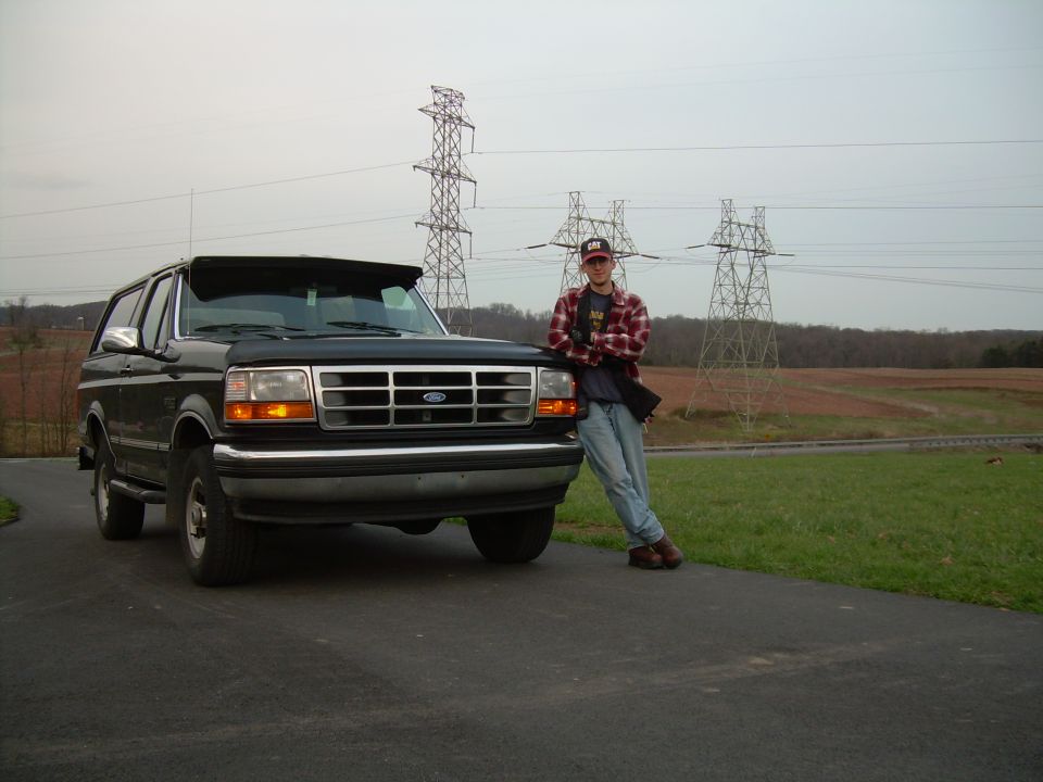 Black 1992 Ford Bronco with a man leaning on the front fender