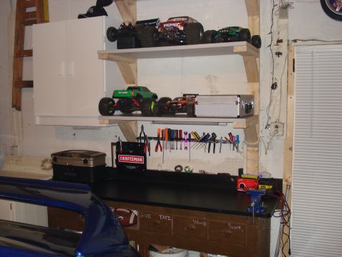1994 Ford Bronco - Workbench and shelves display RC monster trucks and tools in a garage setting.