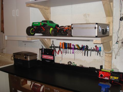 1994 Ford Bronco - A workbench is organized with tools, while two RC monster trucks sit on a shelf above.