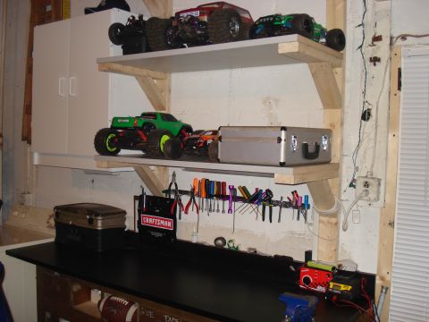 1994 Ford Bronco - A workbench displays remote control monster trucks and various tools, with a toolbox on a shelf above.