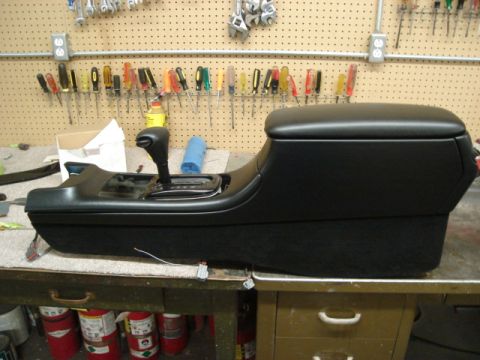 1992 Ford Crown Victoria - A car's center console unit, complete with a gear shifter, is shown on a workbench with tools in the background.