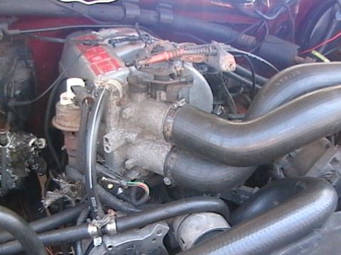 1990 Ford Bronco - Close-up view of an engine bay, showing various hoses and mechanical parts.