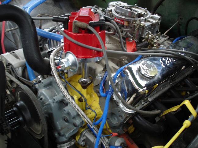 Close-up of V8 engine red distributor and Edelbrock carb with blue wires