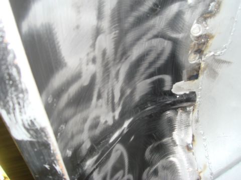 1996 Ford Bronco - Close-up view of a vehicle's inner fender, showing brushed metal and welding marks.