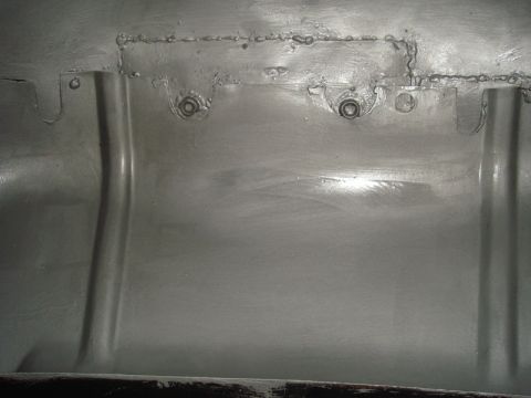 1996 Ford Bronco - This is a close-up view of a vehicle's inner fender, showing construction details like welds and fasteners.