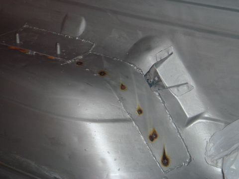1996 Ford Bronco - Detail of a repaired inner fender showing a metal patch with visible rust.