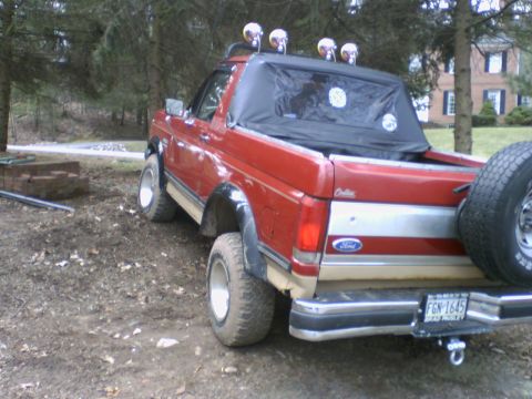 1989 Ford Bronco - This 1989 Ford Bronco is shown in a rear 3/4 view, equipped with off-road lights and a spare tire mounted on the back.