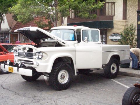 1990 Ford Bronco - White 1958 Dodge D100 pickup truck on display with its hood open.