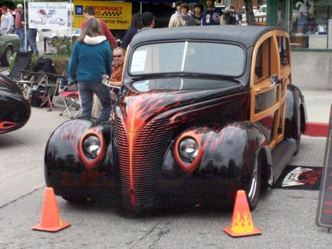 1990 Ford Bronco - A custom hot rod woody wagon with flame graphics is parked on a street.