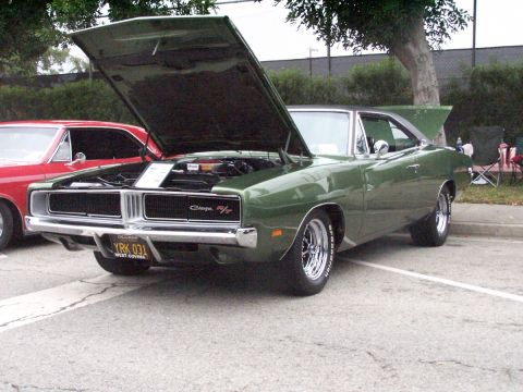 1990 Ford Bronco - A classic green Dodge Charger is displayed with its hood open, parked outdoors next to another vehicle.