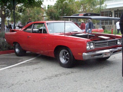 1990 Ford Bronco - A red 1969 Plymouth Road Runner is displayed with its hood up at an outdoor car show.