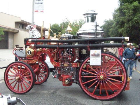 1990 Ford Bronco - An antique fire engine, adorned with gold accents and a Dalmatian, is displayed at an outdoor event.