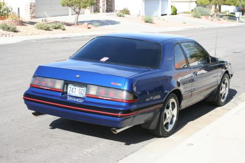 1987 Ford Thunderbird - This 1987 Ford Thunderbird coupe features a distinctive blue paint job with red trim accents and dual exhaust pipes.