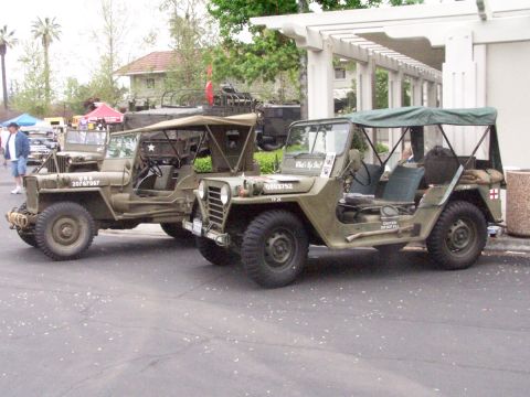 1990 Ford Bronco - Two vintage military jeeps are parked next to each other, displaying various markings and equipment.