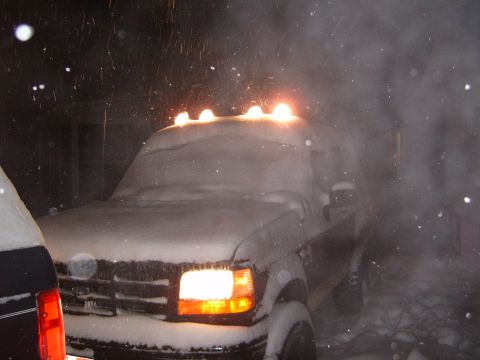 1993 Ford Bronco - A 1993 Ford Bronco is seen covered in snow during a blizzard, with its roof lights illuminated.