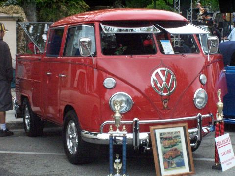 1990 Ford Bronco - A red Volkswagen Type 2 pickup truck is displayed with trophies and a framed picture at an outdoor event.