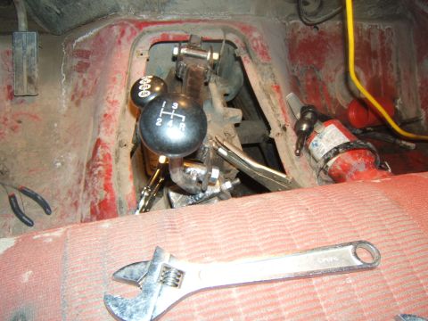 1980 Ford F-250 - Close-up of a manual transmission and 4x4 shifter inside a vehicle, with tools present.