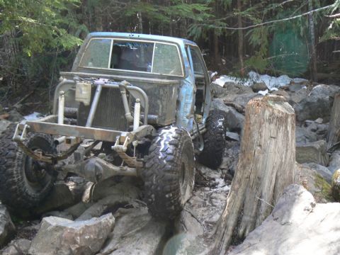 1986 Ford Bronco II - This heavily modified off-road vehicle navigates a challenging rocky path, its build and off-road capabilities.