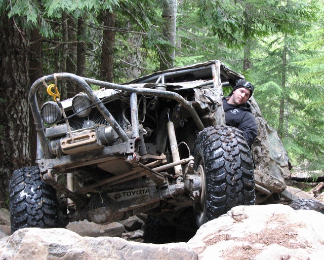 Off-road Toyota with a roll cage and large tires, man in driver's seat