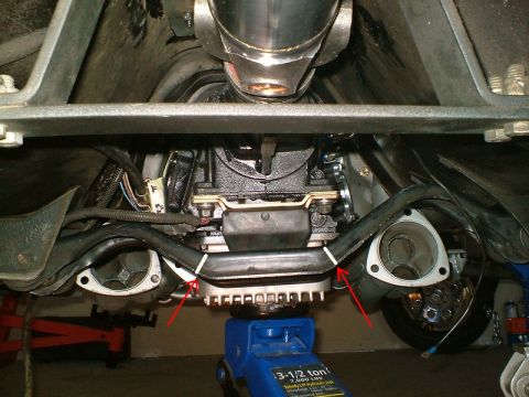 1990 Ford Mustang - Underside view of a vehicle's drivetrain and exhaust system, supported by a hydraulic jack.