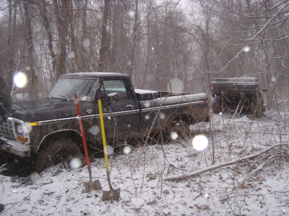 Black 1979 Ford F-250 stuck in snow, with another vehicle in the background