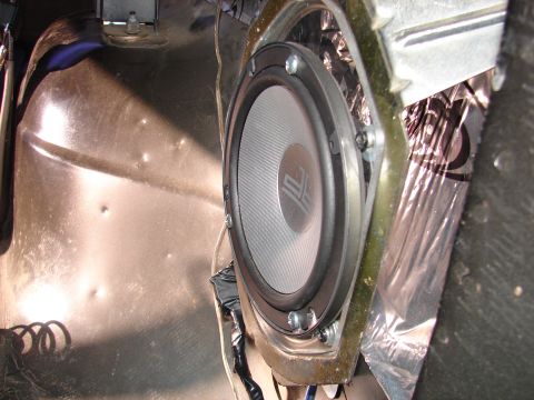 1996 Ford Bronco - Aftermarket speaker installed in a vehicle door, showing sound deadening material.
