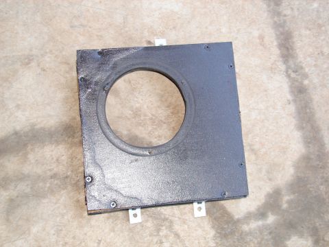 1996 Ford Bronco - A wooden panel with a central hole and metal tabs is shown, possibly a speaker mount.