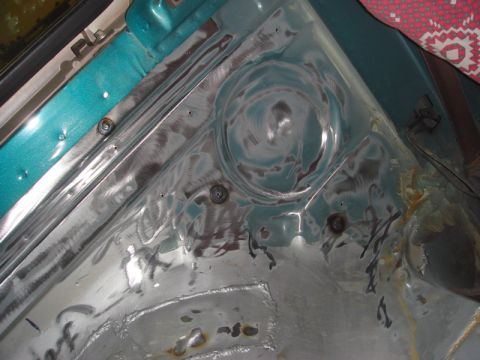 1996 Ford Bronco - Bare metal and teal paint on a vehicle's inner fender area, showing signs of repair and welding.