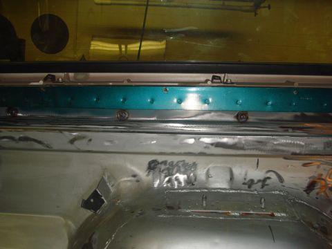 1996 Ford Bronco - The interior of a vehicle shows bare metal and a teal trim piece, possibly during restoration or repair.