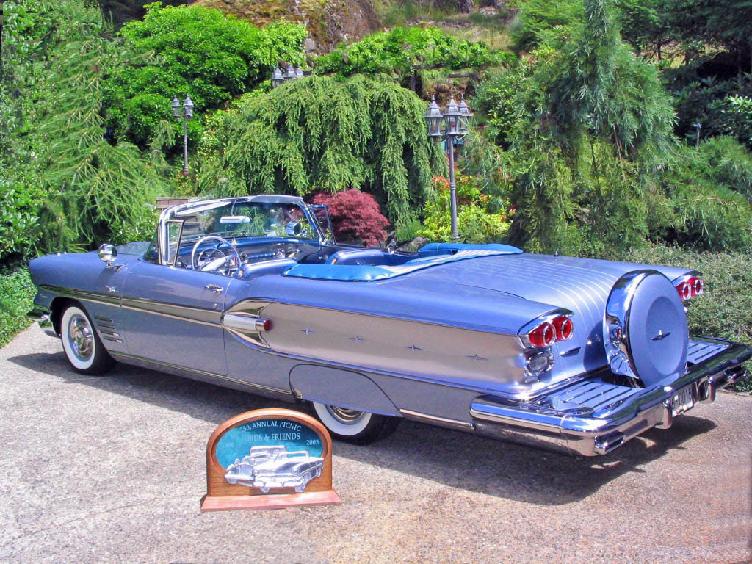 Blue convertible with continental kit parked outside