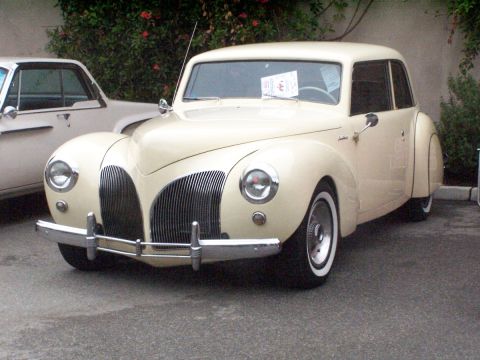 1990 Ford Bronco - A 1940s Lincoln Continental is parked at a car show next to another vehicle.