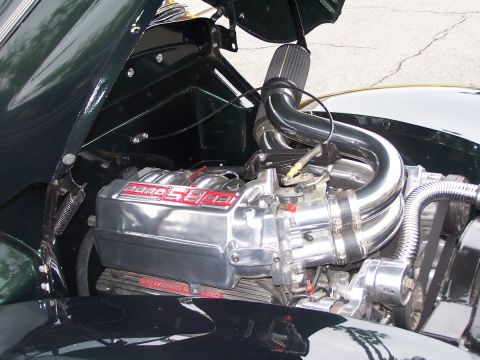 1990 Ford Bronco - Engine bay view of a custom car with a polished supercharger and intake system.