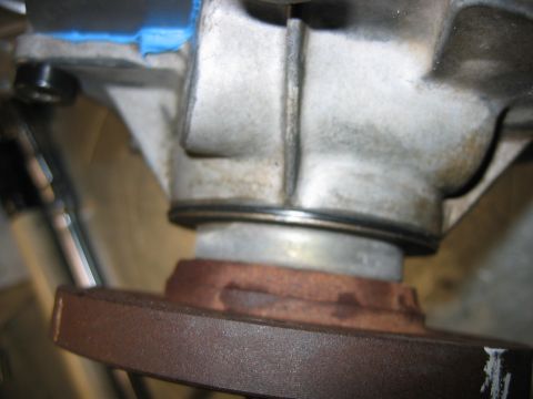 1992 Ford Bronco - A close-up view of a transfer case component, showing a rusty flange and metal housing.