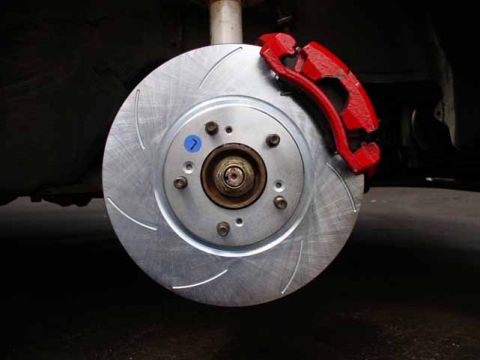 1996 Ford Probe - Aftermarket slotted brake rotor and red caliper assembly.
