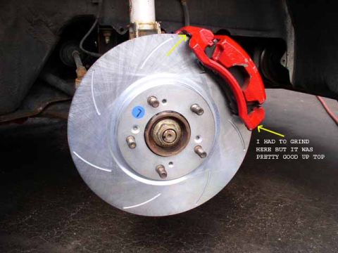 1996 Ford Probe - A red brake caliper is shown installed over a slotted brake rotor.