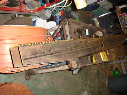 1989 Ford Bronco - A rusty metal beam marked 'Front Axle' is seen in a cluttered garage setting.